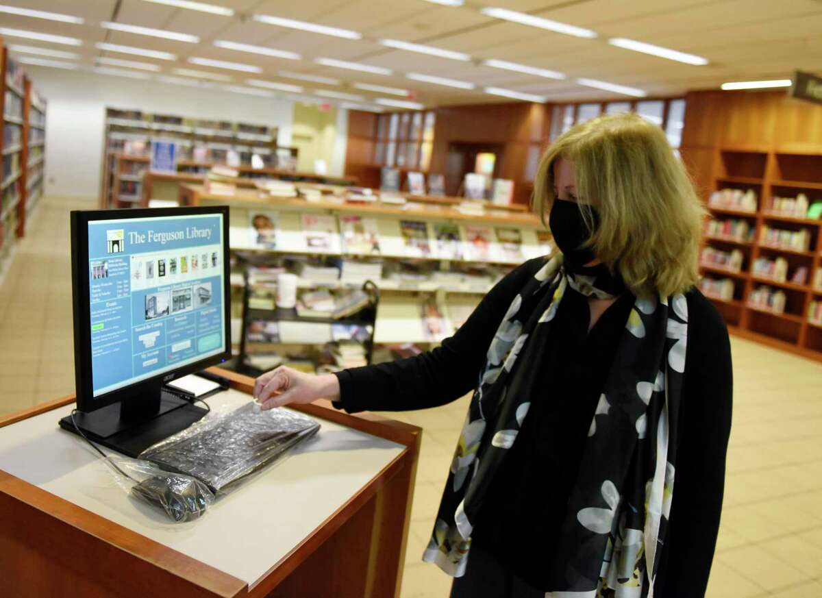 Library President Alice Knapp shows the plastic protected keyboard and mouse at the computer kiosks at Fergsuon Library in Stamford, Conn. Thursday, Feb. 4, 2021. Outside agencies got a cash infusion from the city's planning board in this year's budget recommendation, and the Ferguson Library was one of the organizations to reap the benefit.