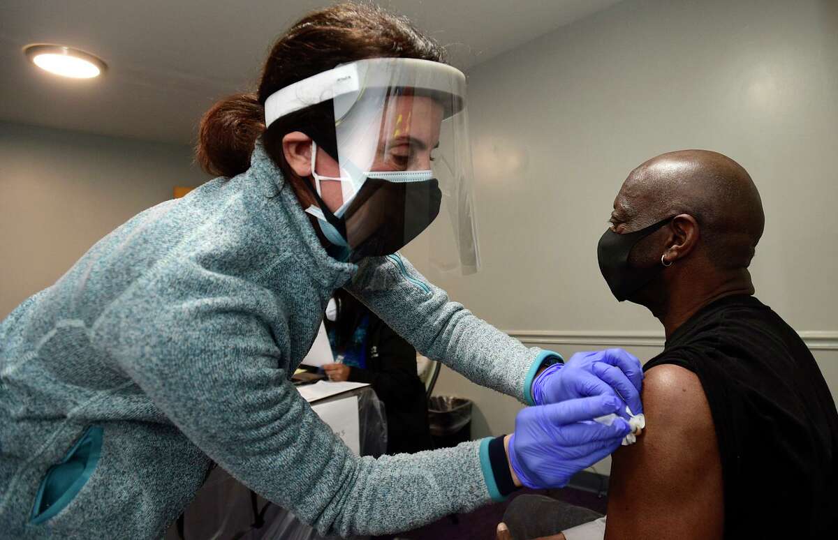 Angela Matera administers a shot to Stamford resident Mark Lyde during a pop-up clinic for COVID-19 vaccination Saturday, February 27, 2021 for first and second doses at the Bethel AME Church in Stamford, Conn. This clinic is set up to support vaccination within communities of color and for those who do not have the ability to make appointments online. The clinic will be held again on March 27 (10am-3pm).