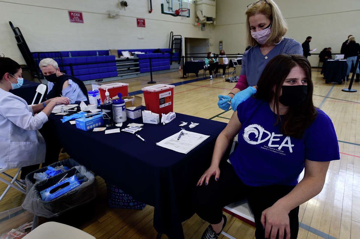 Darien Superintendent of Schools, Alan Addley, and Darien teachers' union president, Joslyn Delancey, get vaccinated against the coronavirus Saturday, March 6, 2021, at Town Hall in Darien, Conn.