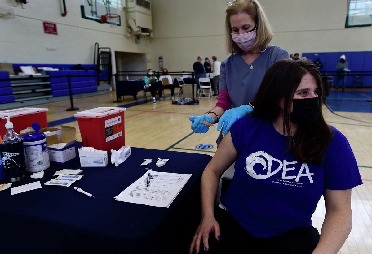 Darien teachers' union president Joslyn Delancey gets vaccinated against the coronavirus Saturday, March 6, 2021, at Town Hall in Darien, Conn.