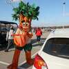 San Antonio Parks and Recreation’s new tree mascot, Parker the Texas Red Oak, carries a tree to a waiting vehicle at a Texas A&M San Antonio parking lot Saturday, March 6, 2021. Each vehicle received one tree: either lemon, fig, nectarine, apple, lime, pear or orange.