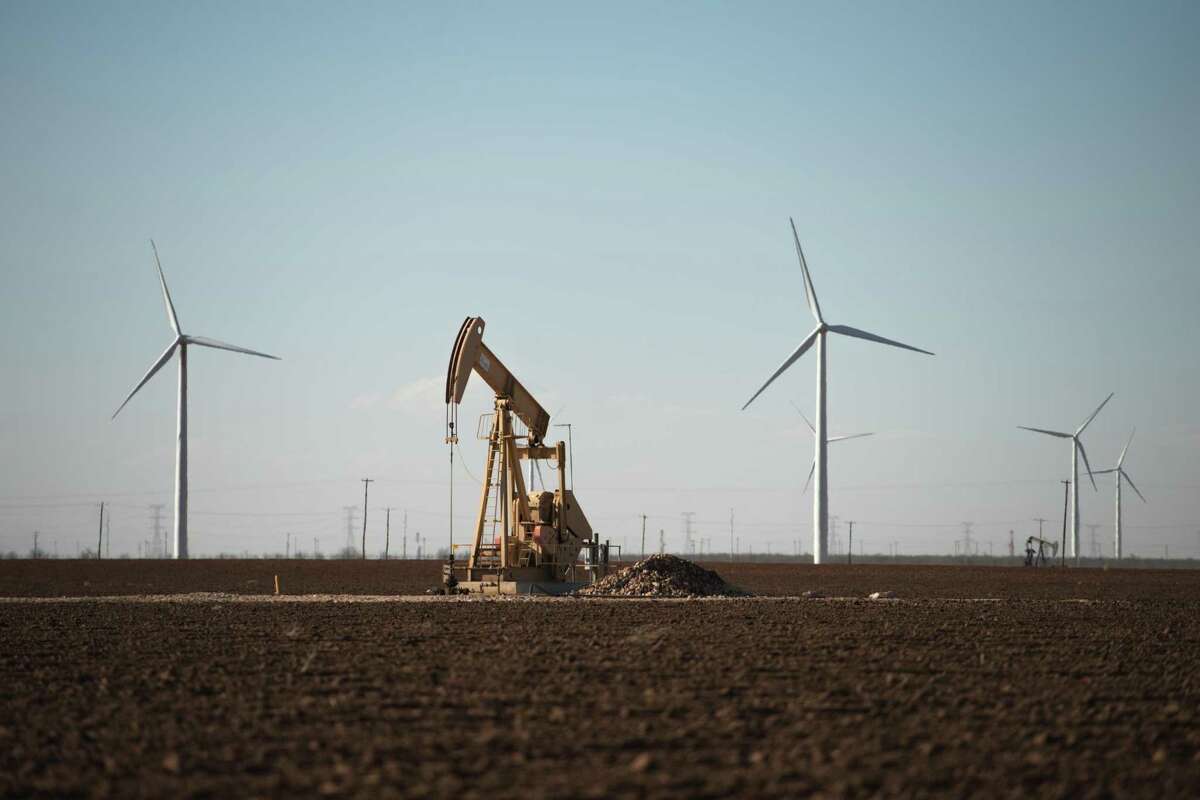 FILE — An oil pump jack and wind turbines near Stanton, Texas, on Feb. 21, 2019. A day after Democratic presidential nominee Joe Biden called for a transition away from oil and natural gas, industry executives said the country would need fossil fuels for decades to come. (Brandon Thibodeaux/The New York Times)