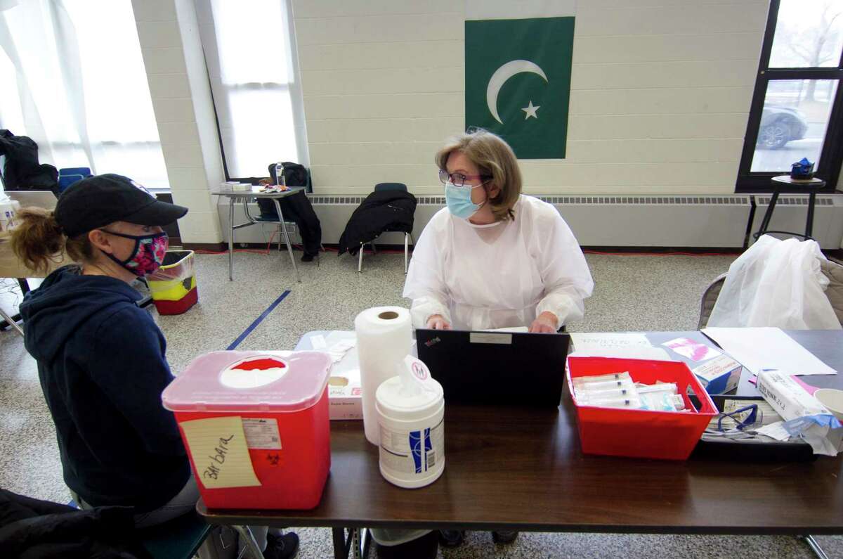Karen Lynch, a nurse at Danbury Hospital, administers the Moderna COVID-19 vaccination to Danbury teacher Paige Best during a vaccine clinic at Rogers Park Middle School in Danbury, Conn., on Saturday Mar. 6, 2021. Over 900 teachers and staff received the Moderna vaccine during the two-day clinic.