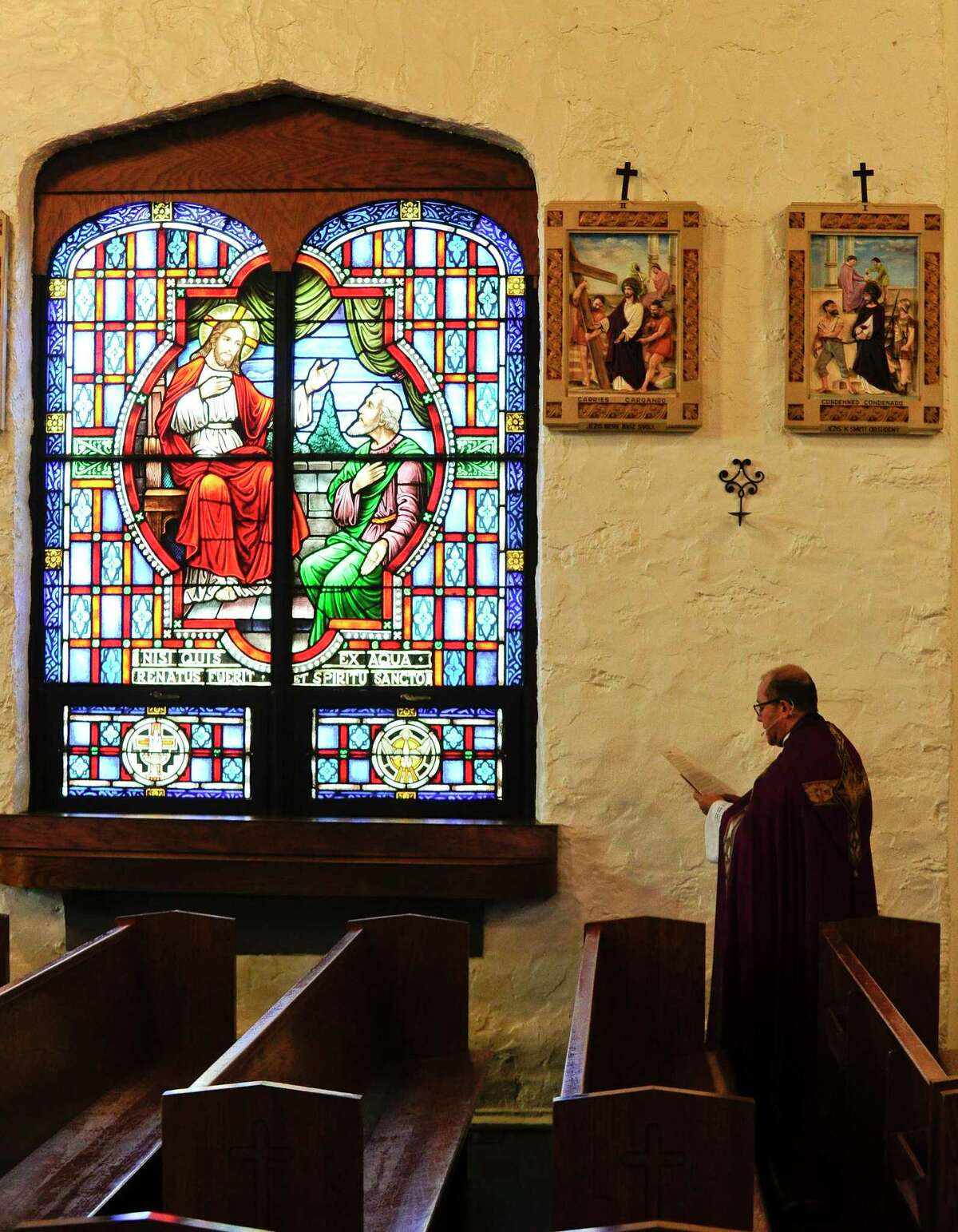Rev. Jose Montoya, Parochial Vicar of St. Mary's Church, stands before one of the 14 Stations of the Cross as he reads a reflection inside the empty sanctuary of St. Benedicts Church, while being video for a Good Friday Mass on April 10, 2020 in Stamford, Connecticut. In response the the COVID-19 Pandemic, many clergy and churches have had to look to alternatives ways to present Easter services with their parishioners. Usually, the combined parishes of St. Mary's and St. Benedict's, hundreds gather for a pilgrimage walk from Cummings Beach to the front steps of St. Mary's Church, with priests reciting reflections for the 14 Stations of the Cross, culminating with a Good Friday Mass. A video of Reverend Montoya's reflection can be found on his YouTube page @ https://www.youtube.com/watch?v=1iUg0t850qg