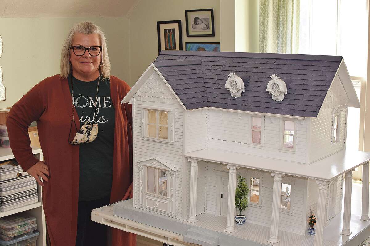 Julie Rowe shows the dollhouse re-creation of her childhood home.