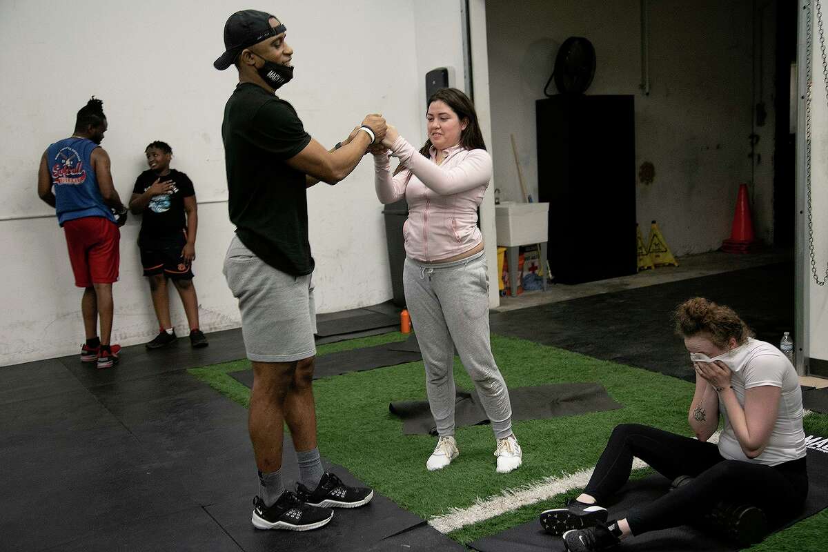 Jeremy McDonald, co-owner of MacFit Athletics, fist bumps client Angie McDonald at the conclusion of a group fitness class at MacFit Athletics in San Antonio on March 4, 2021.