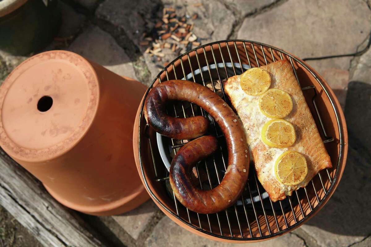 Finished smoked sausage and salmon that was cooked entirely inside a pair of flower pots with wood chips and an electric hot plate.