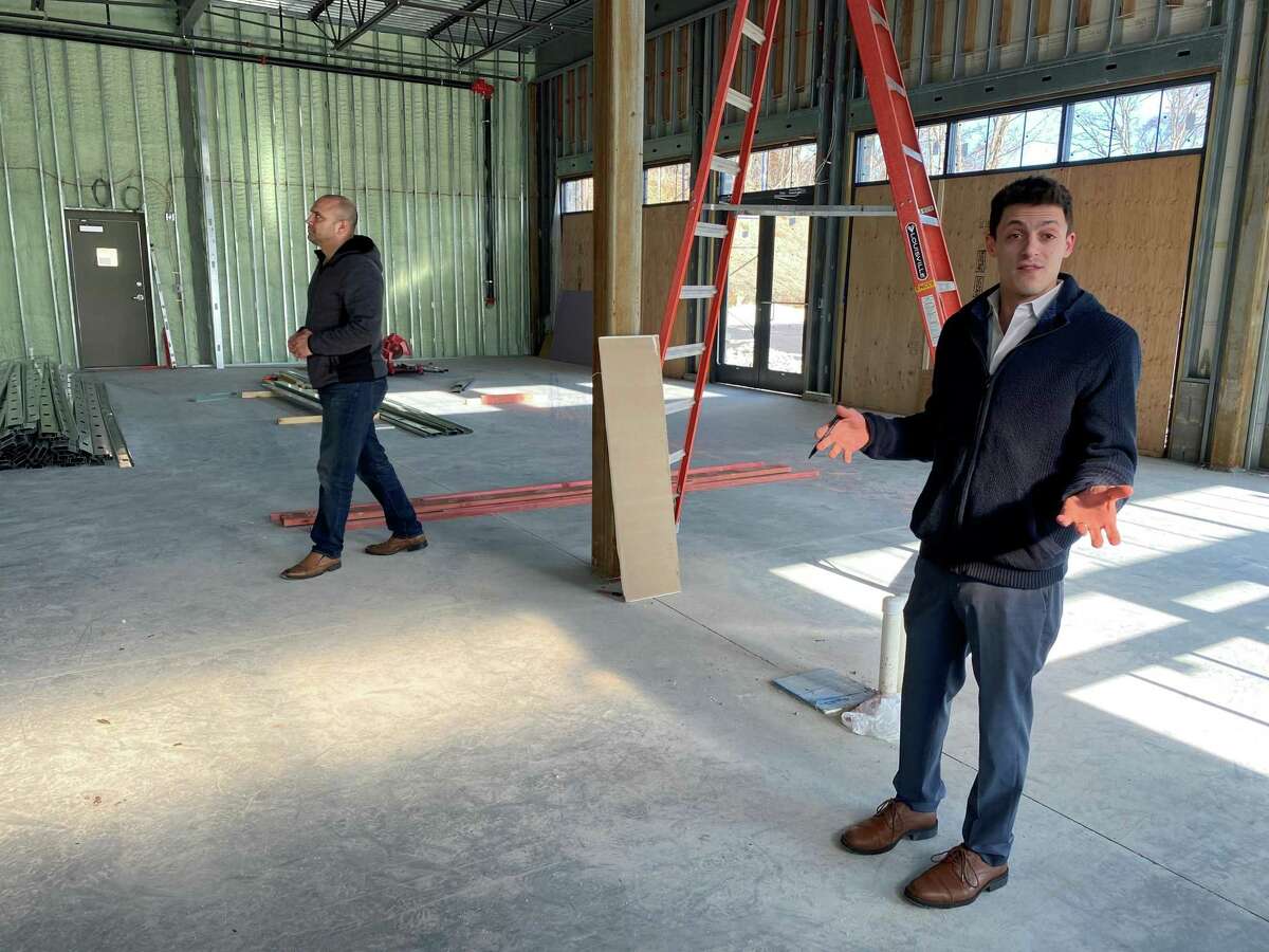 Joe Worthington describes the custom bar that will be the centerpiece of the new Ecco restaurant while Dan Camporeale inspects the framing on Thursday, March 4.