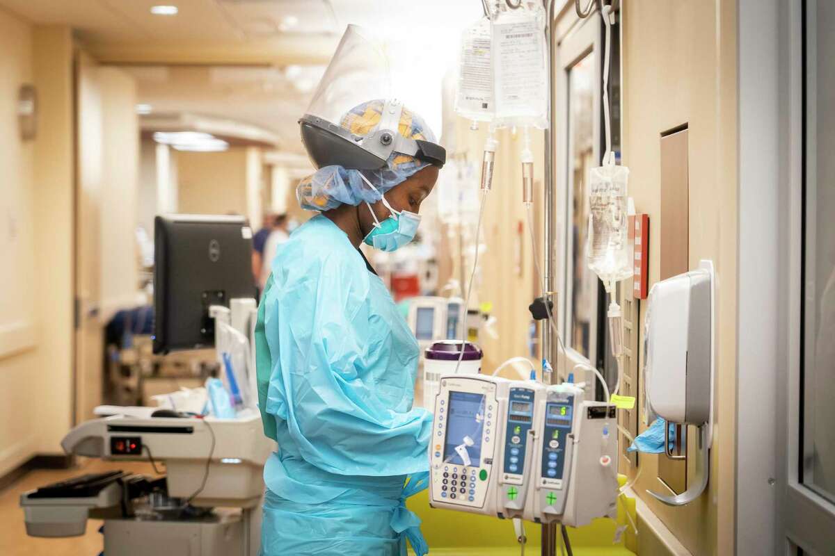 Memorial Hermann Hospital RN Jacqueline Uwanda prepares to enter a COVID patient's room inside a 38-bed ICU treating mostly COVID patients, Tuesday, Jan. 5, 2021, in Houston's Texas Medical Center.