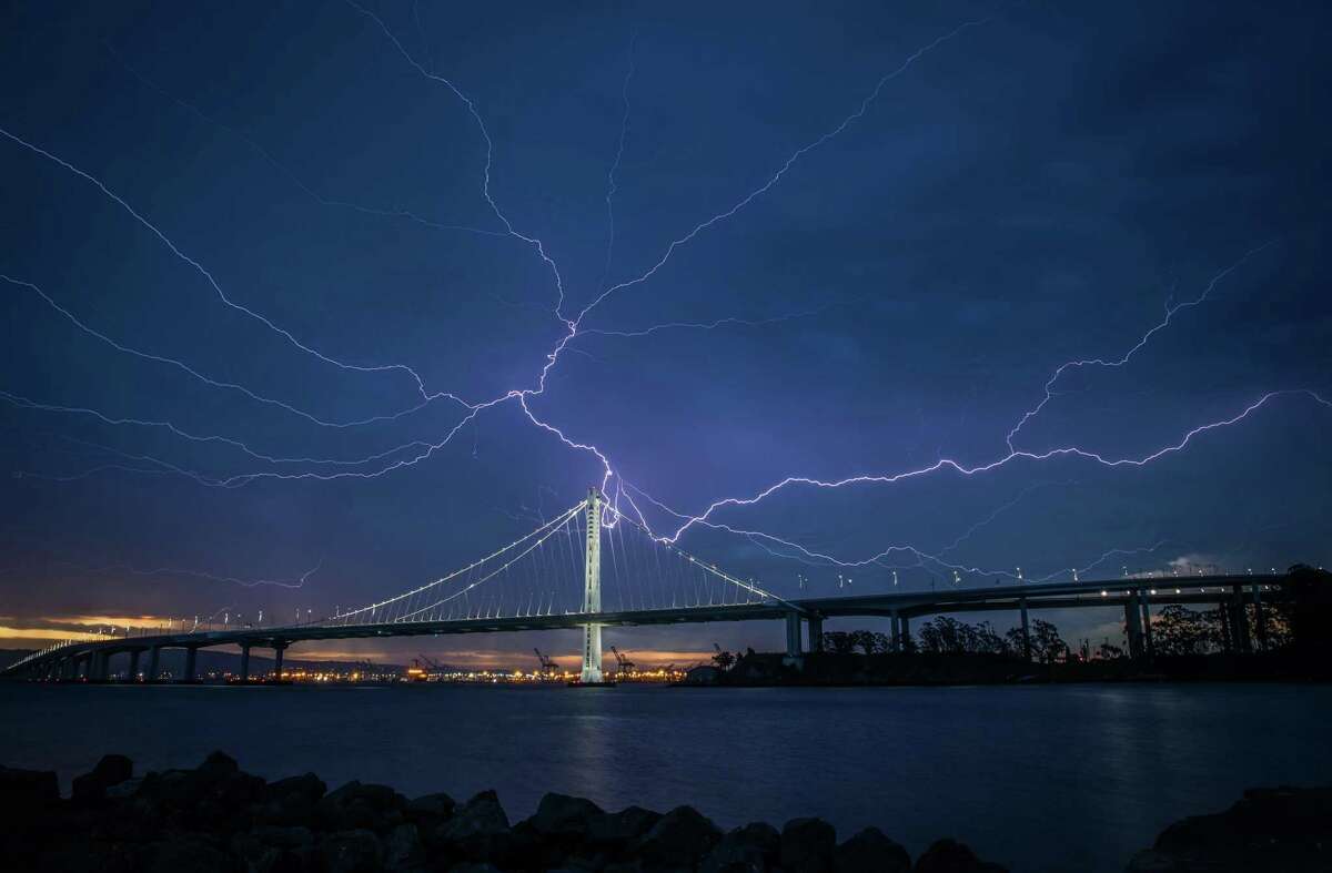 Lightning illuminates the sky over the eastern span of the Bay Bridge as a storm passed through the area on Sunday morning in San Francisco, Calif., on Sunday, August 16, 2020.