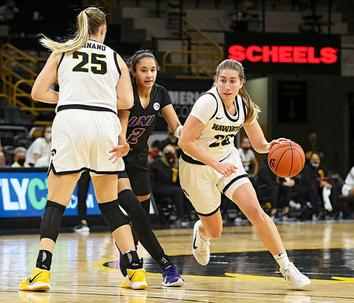 Iowa’s Kate Martin (right), a redshirt sophomore from Edwardsville, drives Northern Iowa’s Cailyn Morgan into a screen set by the Hawkeyes’ Monika Czinano (25) during a Nov. 25 game in Iowa City, Iowa.
