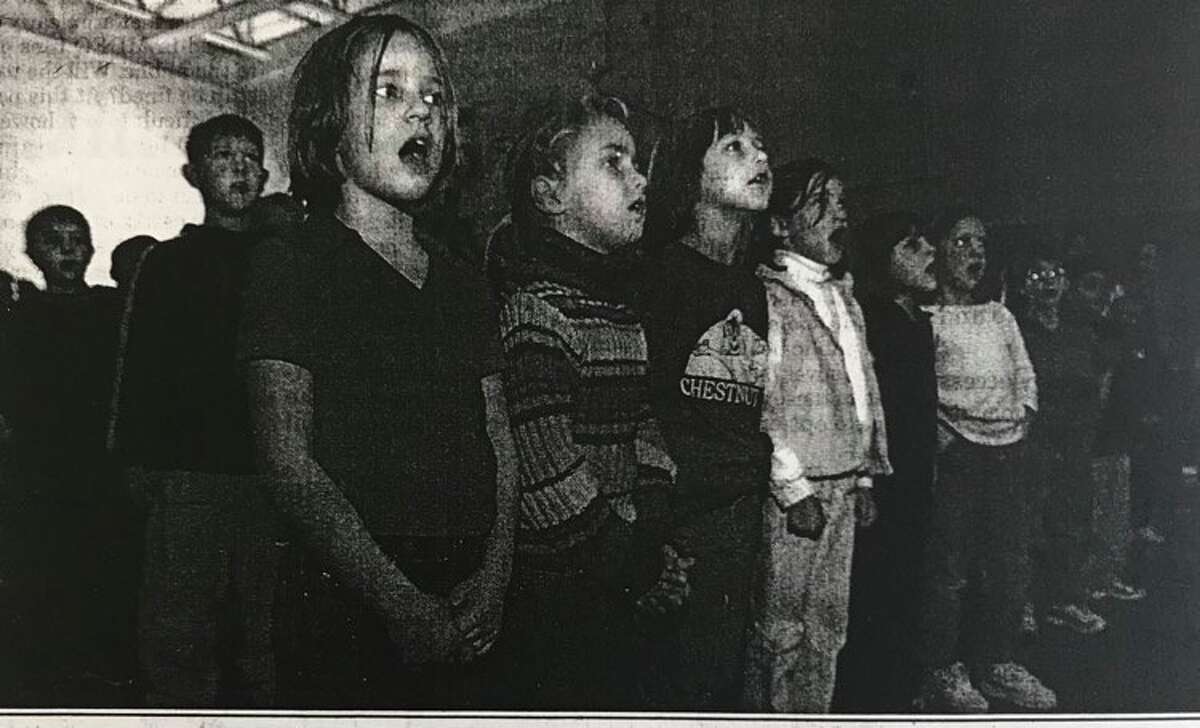 From left, Chestnut Hill students Gabby Axtell, Gretchen Holzhauer, Amy Felzke and Bianca Cuccioli, join more than 250,000 school children throughout the United States at 1:30 p.m. Thursday, Nov. 8, 2001, singing "God Bless America."