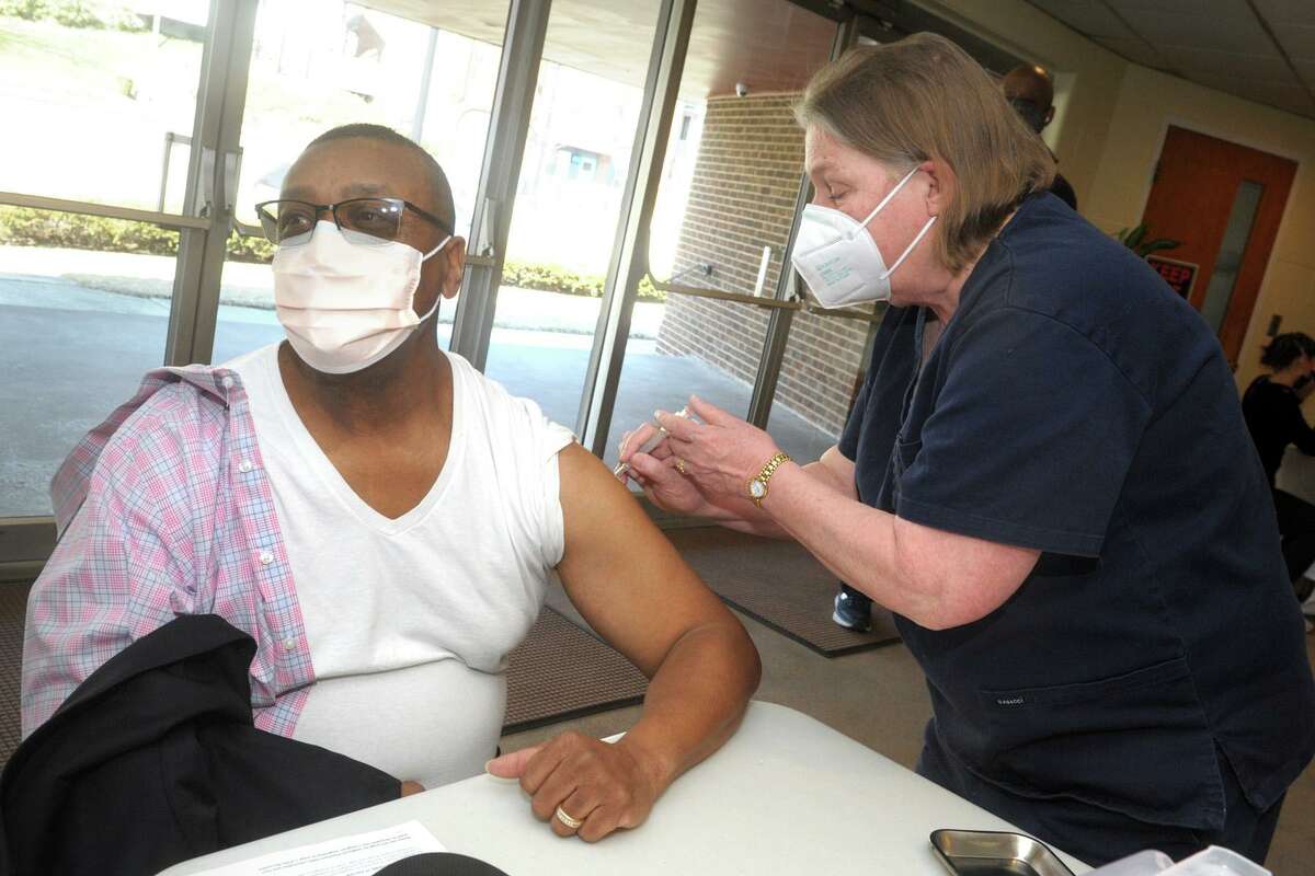 Rev. James Newman of Mt. Zion Baptist Chruch, in Norwalk, receives a COVID-19 vaccination from nurse Barbara McCabb during at a vaccination clinic at Grace Baptist Church in Norwalk on Tuesday.