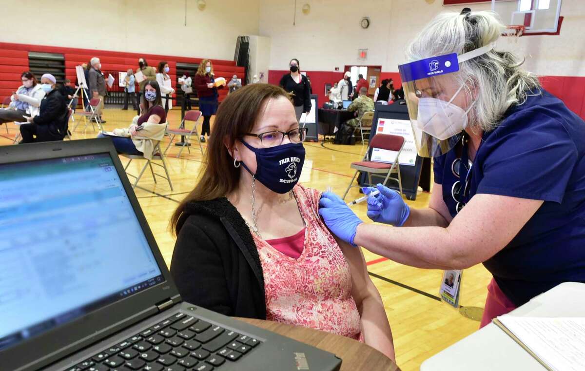 Sixth-grade bilingual teacher Ingrid Cuevas of the Fair Haven School in New receives her Covid-19 vaccination at the Wilbur Cross H.S. gymnasium on March 9, 2021.