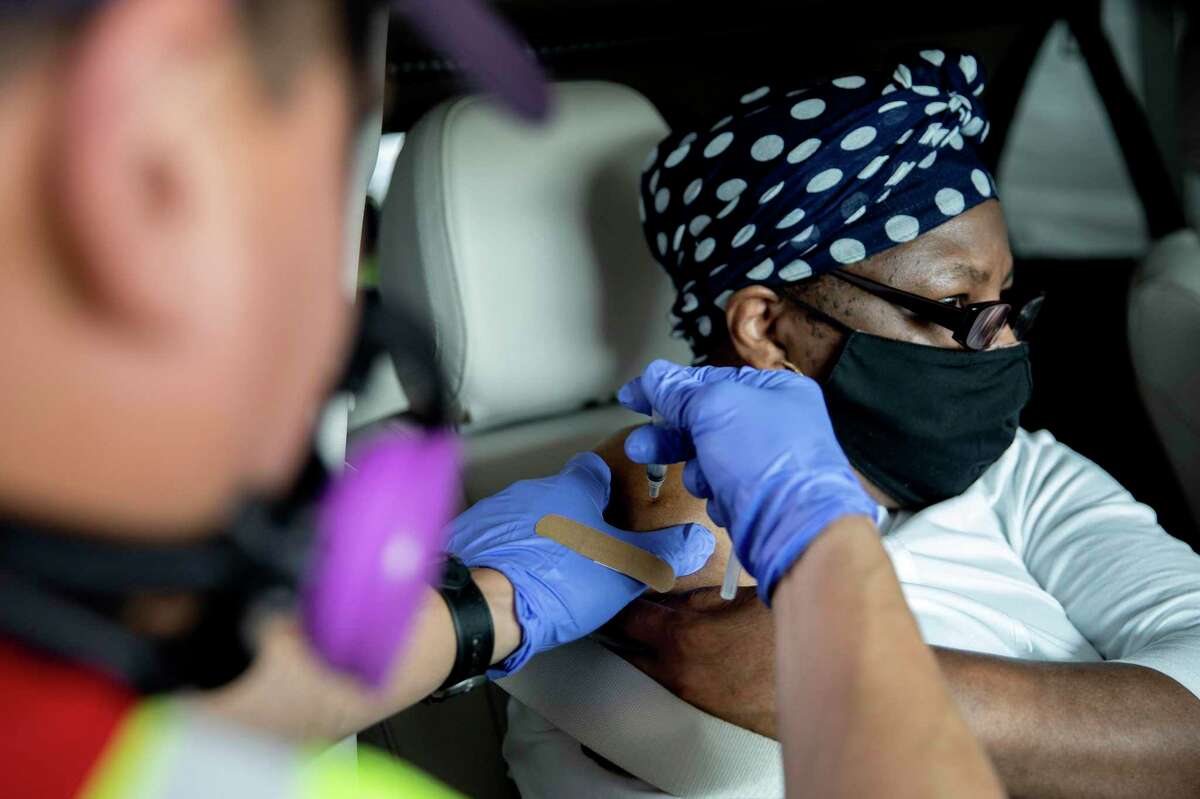 Barbara Washington, 65 receives her first dose of the Moderna COVID-19 vaccination on Jan. uary 29, 2021, in a drive-thru vaccination line at the Alamodome.