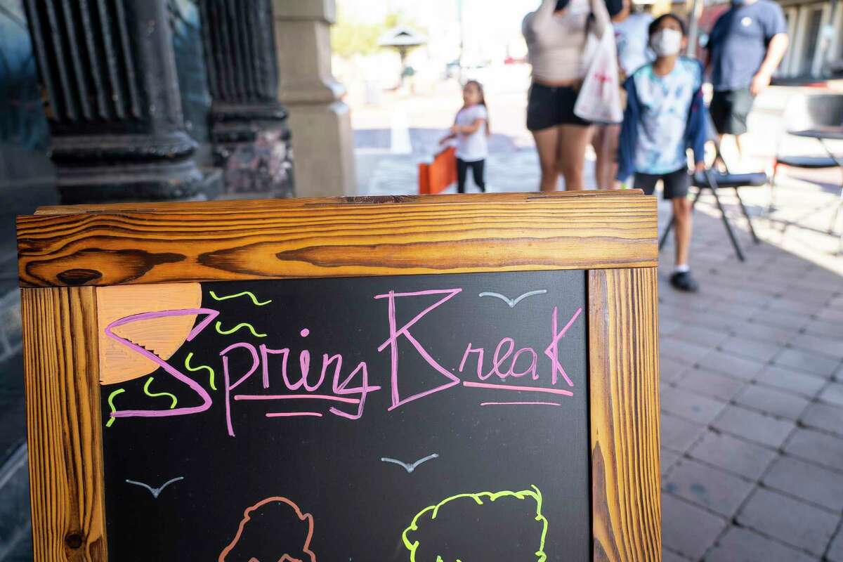 A shop advertises that Spring Break is coming as people walk past shops in The Strand on Tuesday, March 9, 2021, in Galveston. The island is preparing for the start of Spring Break next week.