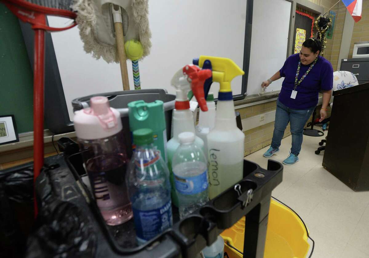 Karen Cabrera, pictured here in March of 2020, wipes a board and walls as she and fellow custodians continue deep cleaning at Vidor High School. Nearly a year later, the district is the first in the region to lift a mask mandate after the state announced that districts had the option to do so last week. Photo taken Monday, March 16, 2020 Kim Brent/The Enterprise