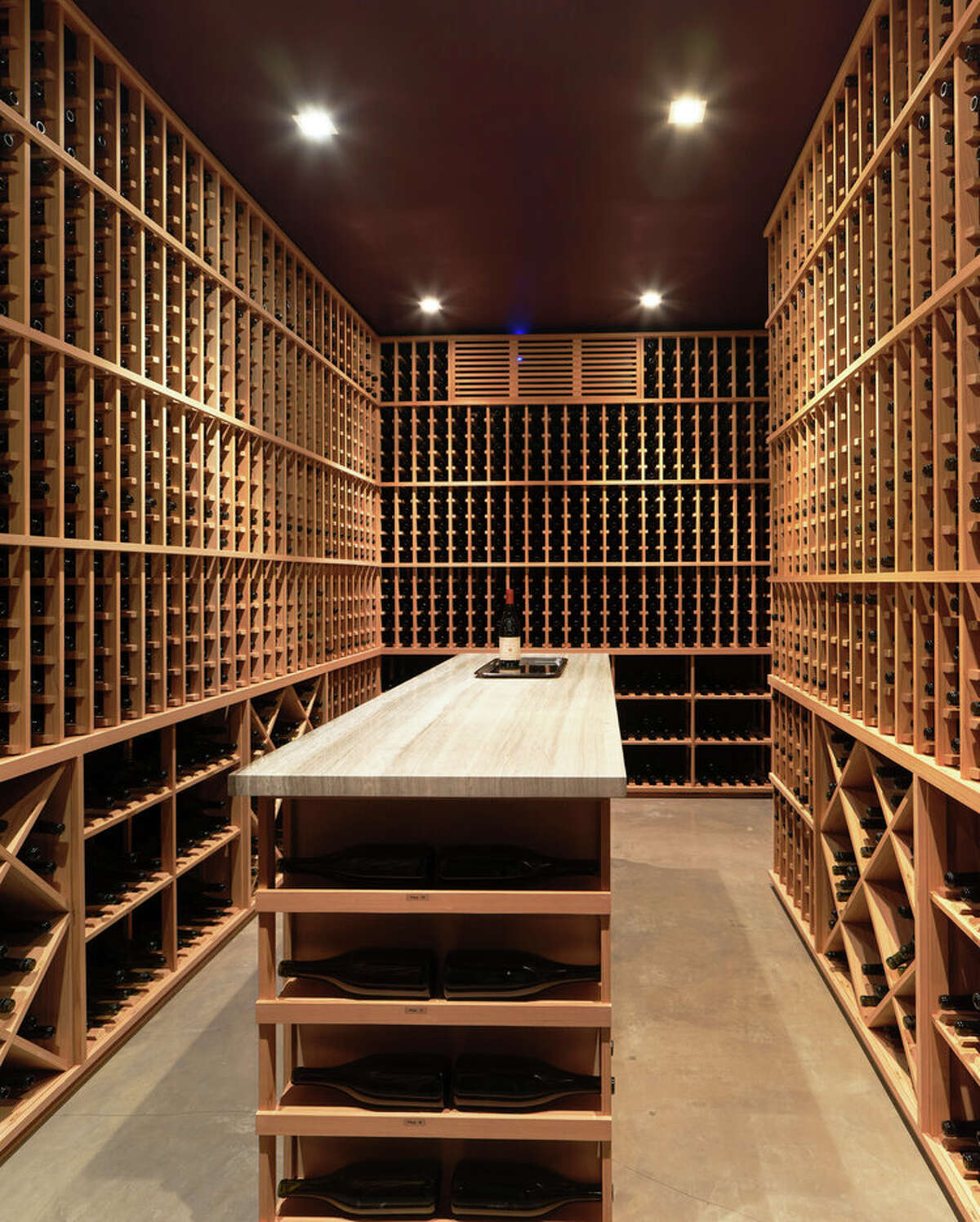 The aforementioned wine room is on the lowest level, which is accessed via a terraced entry that sits atop a two-car side-by-side garage. This floor also has a full bath and a media room with 110-inch drop-down projection screen and surround sound.