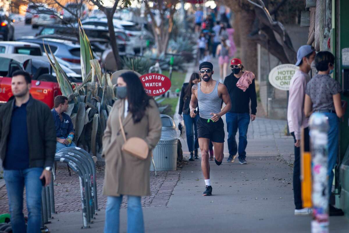 AUSTIN, TX - MARCH 03: Pedestrians walk down South Congress Ave. on March 3, 2021 in Austin, Texas. Gov. Greg Abbott announced today that the state will end its mask mandate and allow businesses to reopen at 100 percent capacity on March 10. (Photo by Montinique Monroe/Getty Images)