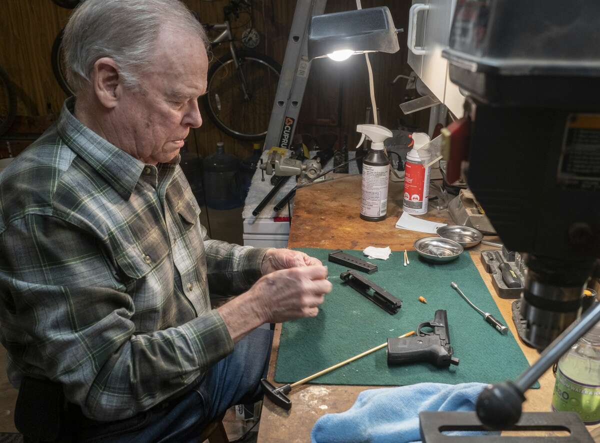 Morris Burns concentrates as he works on cleaning his Sig P239 Dec. 17 at his gunsmith table. Burns said his favorite gun is the 1911 .45-caliber Colt Army.