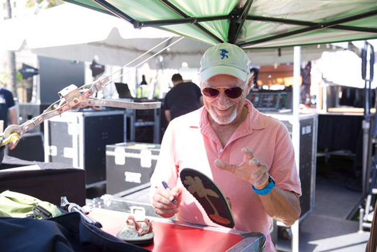 Jimmy Buffett is pictured signing a flip flop for a Parrothead fundraiser. There are more than 200 Parrothead clubs across the world.