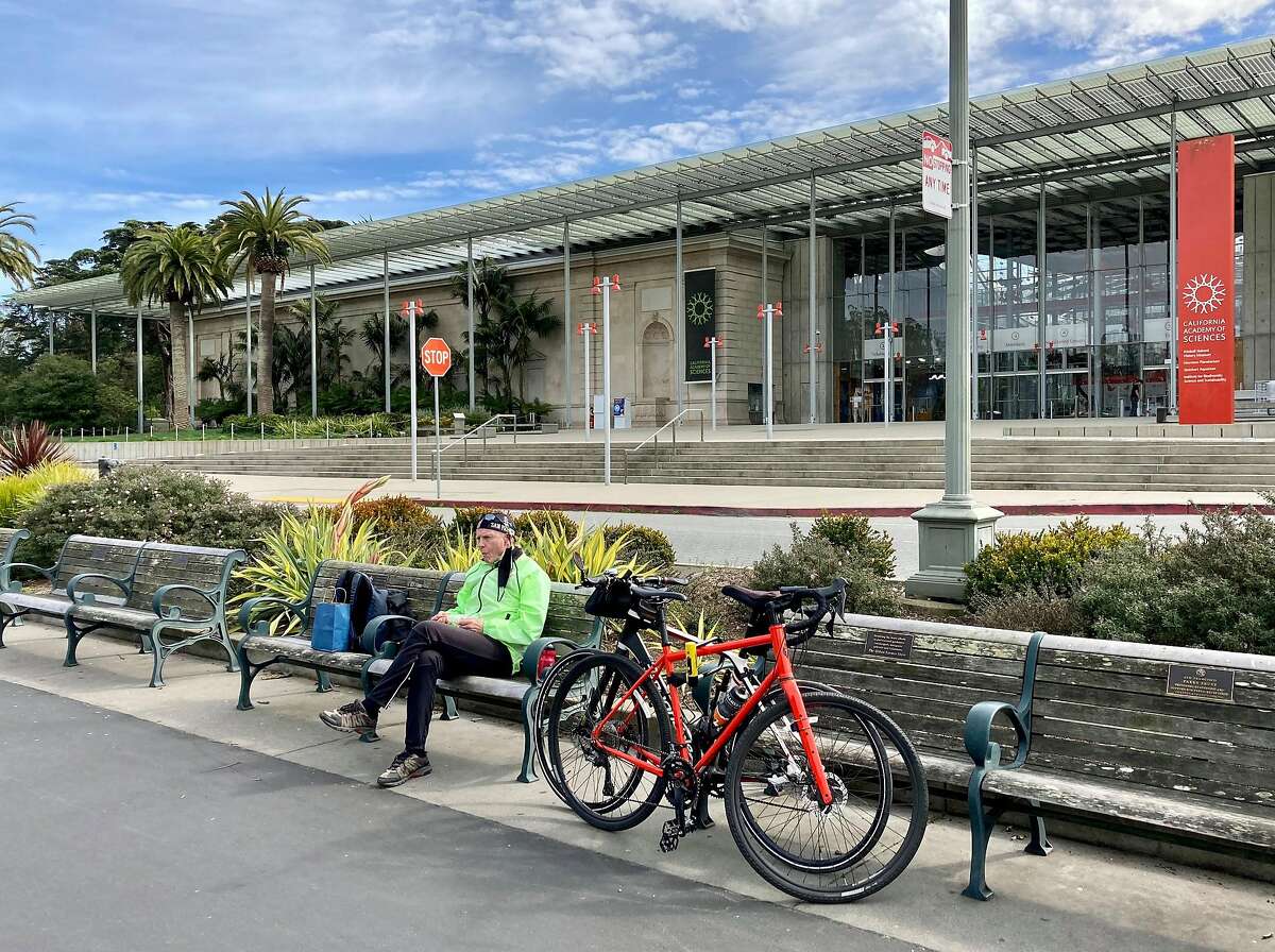 86岁的菲利普·哈特劳布(Philip Hartlaub)从阿拉米达(Alameda)骑车到金门公园(Golden Gate Park)后，在加州科学院前吃午饭。
