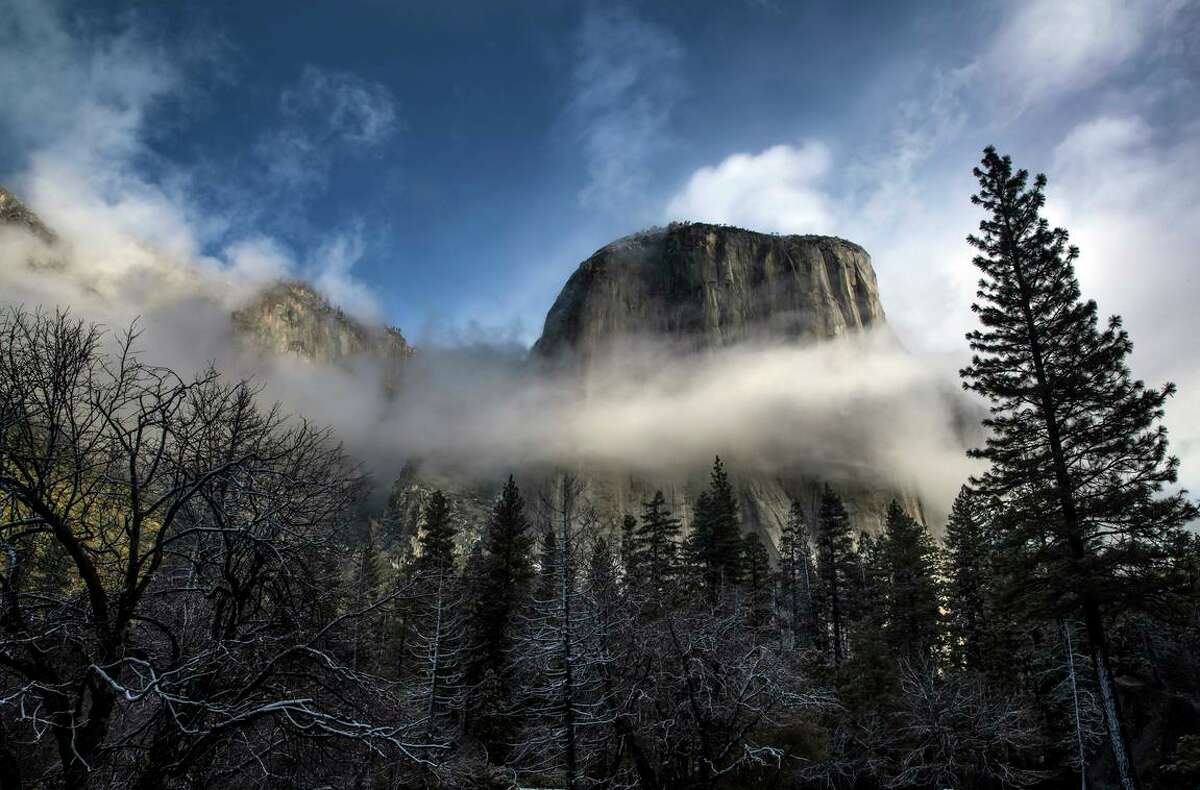 El Capitan shrouded in clouds in Yosemite National Park outside Merced, Calif., on Saturday, February 20, 2021. Every February the park is descended upon by visitors hoping to catch the “Firefall” event when the setting sun lights up Horsetail Fall causing it to glow red-orange along with a small area of the rock face of El Capitan.