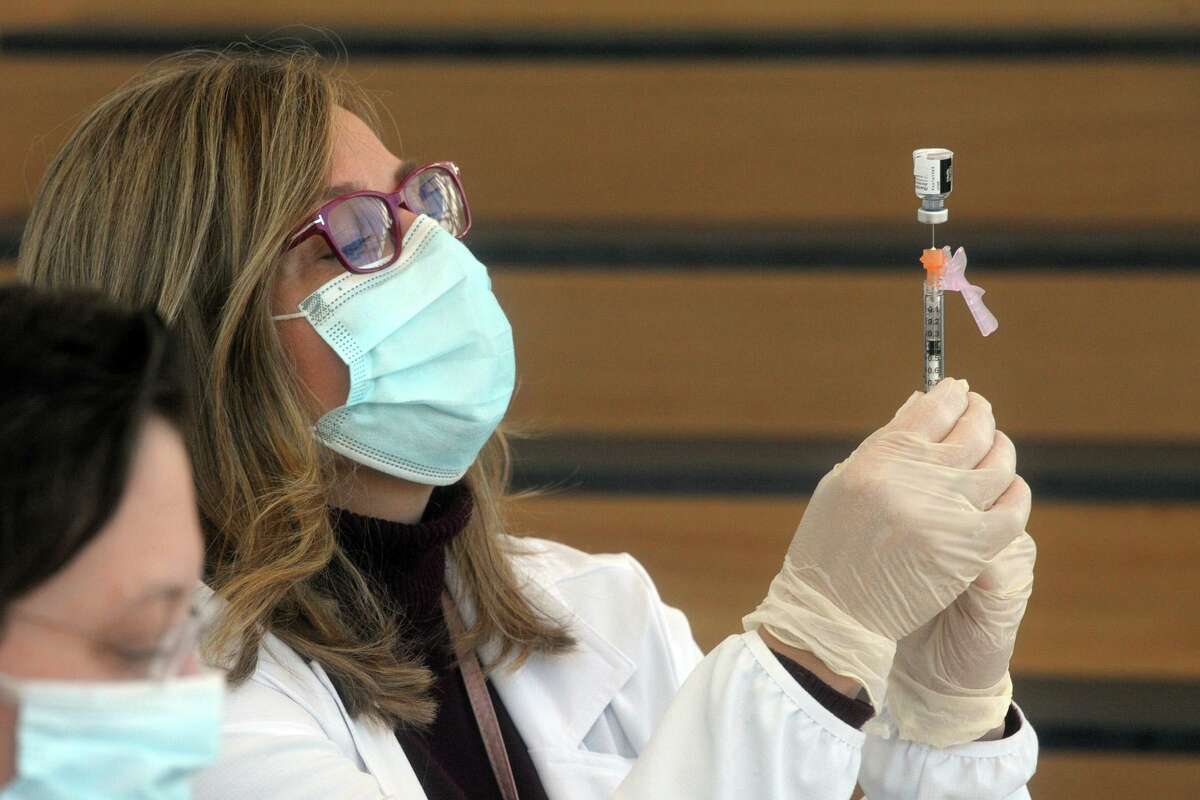 Gina Christakos fills a syringe with COVID-19 vaccine at Hartford HealthCare’s new mass vaccination clinic on the west campus of Sacred Heart University, in Fairfield, Conn. March 10, 2021.