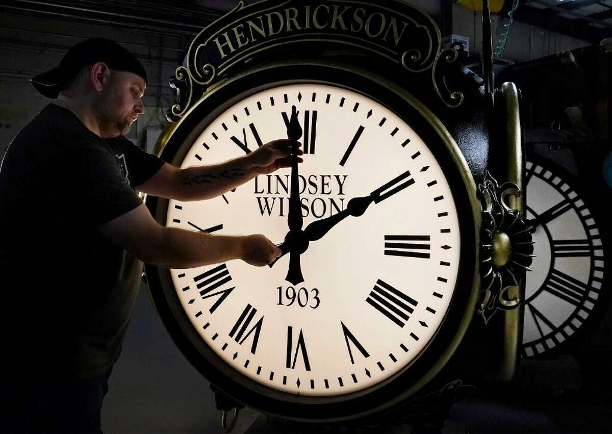 Dan LaMoore adjusts the hands on a Seth Thomas Post Clock at Electric Time Company, Friday, Oct. 23, 2020, in Medfield, Mass. Daylight saving time ends at 2 a.m. local time Sunday, Nov. 1, 2020, when clocks are set back one hour.