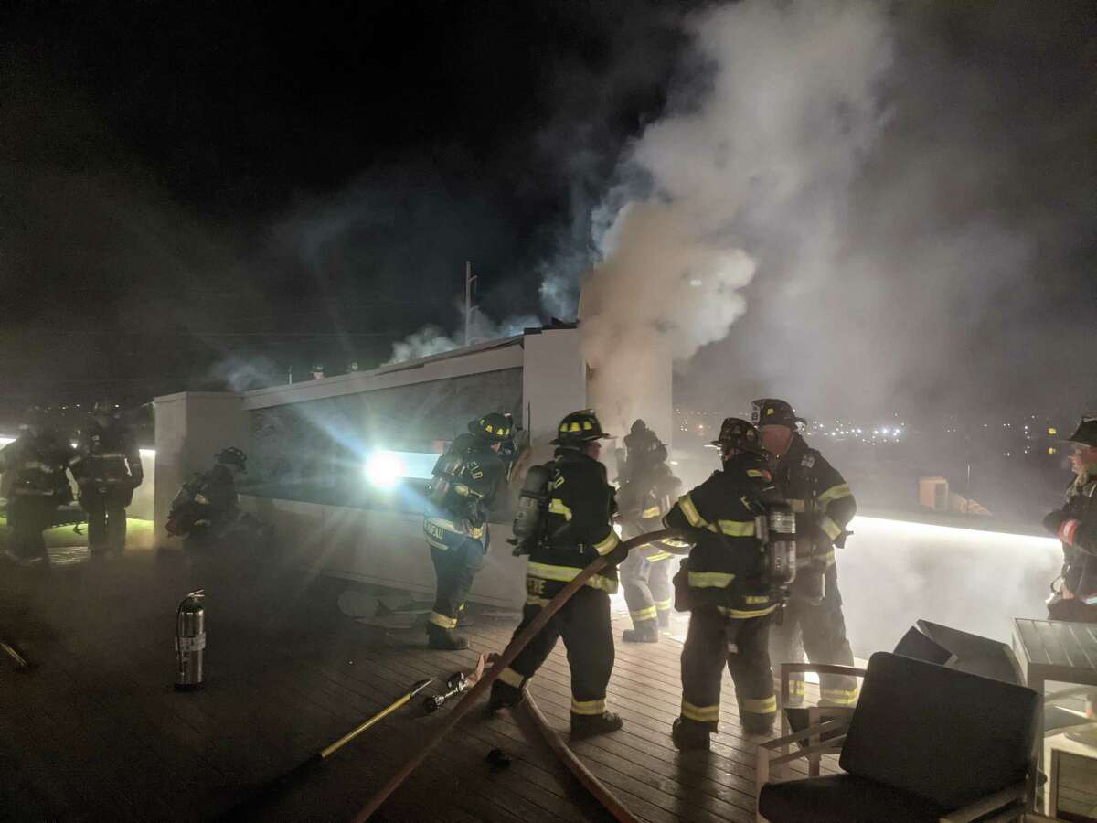 Firefighters operating at a fire on the rooftop deck of the Alto Fairfield Metro Complex on Kings Highway in Fairfield, Conn., on March 10, 2021.