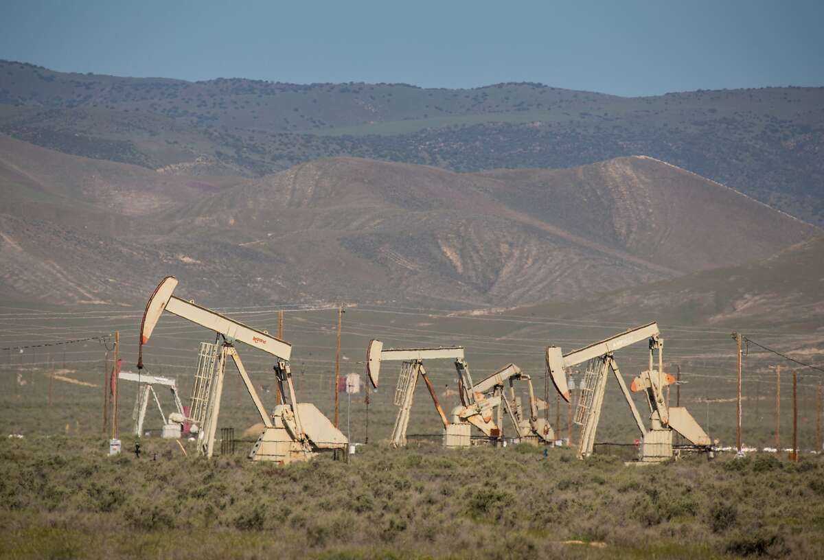 Oil pumping rigs and transmission lines dot the landscape along Highway 33. Kern County has approved a policy to streamline approvals, potentially allowing 2,700 oil and gas wells annually.