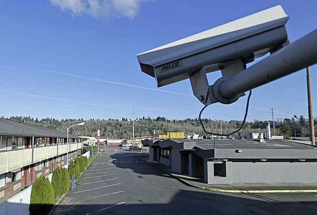 In this March 4, 2020 photo, a security camera is shown on the second floor of a row of rooms at a motel in Kent, Wash. Hackers aiming to call attention to the dangers of mass surveillance said they were able to peer into hospitals, schools, factories, jails and corporate offices after they broke into the systems of a security-camera startup. That California startup, Verkada, said Wednesday it is investigating the scope of the breach, first reported by Bloomberg, and has notified law enforcement and its customers.