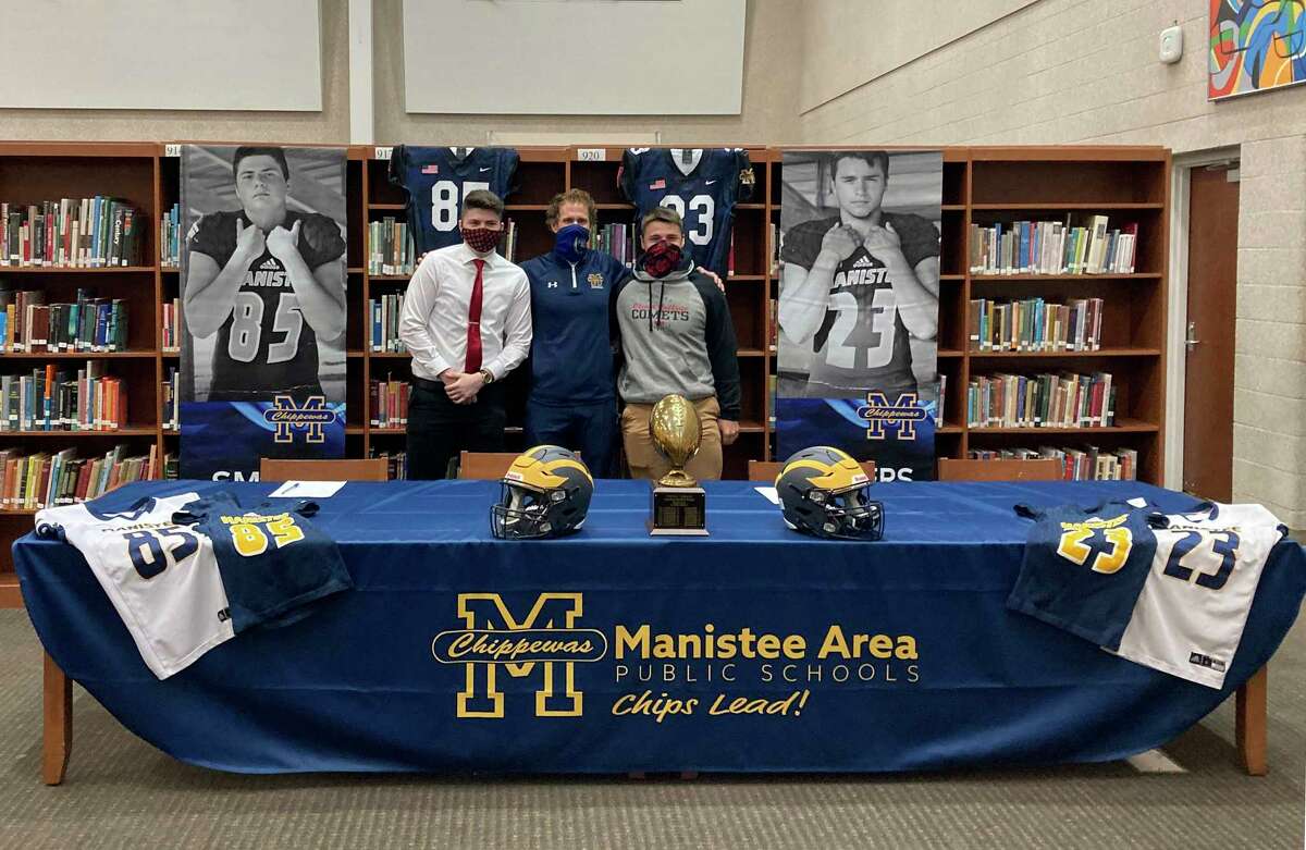 Manistee's Eric Smith (left) and Landen Powers (right) are joined by Chippewa football coach Troy Bytwork at a signing ceremony this week. The two will play football for Olivet College next year. (Dylan Savela/News Advocate)