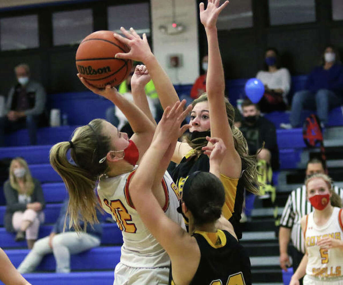 Roxana’s Olivia Mouser (left) shoot over EA-WR’s Hannah Allen in their girls basketball rivalry game Thursday night at Larry Milazzo Gym in Roxana. Mouser, one of two seniors honored before the game, scored a game-high 16 points in the Shells’ win.