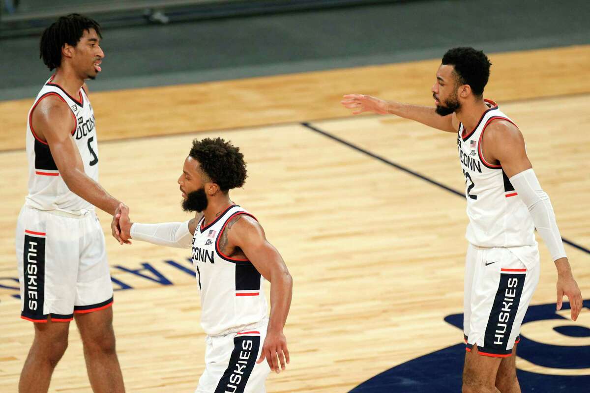 NEW YORK, NEW YORK - MARCH 11: Isaiah Whaley #5, R.J. Cole #1, and Tyler Polley #12 of the Connecticut Huskies high-five in the second half against the DePaul Blue Demons during the Quarterfinals of the Big East Tournament at Madison Square Garden on March 11, 2021 in New York City. (Photo by Sarah Stier/Getty Images)