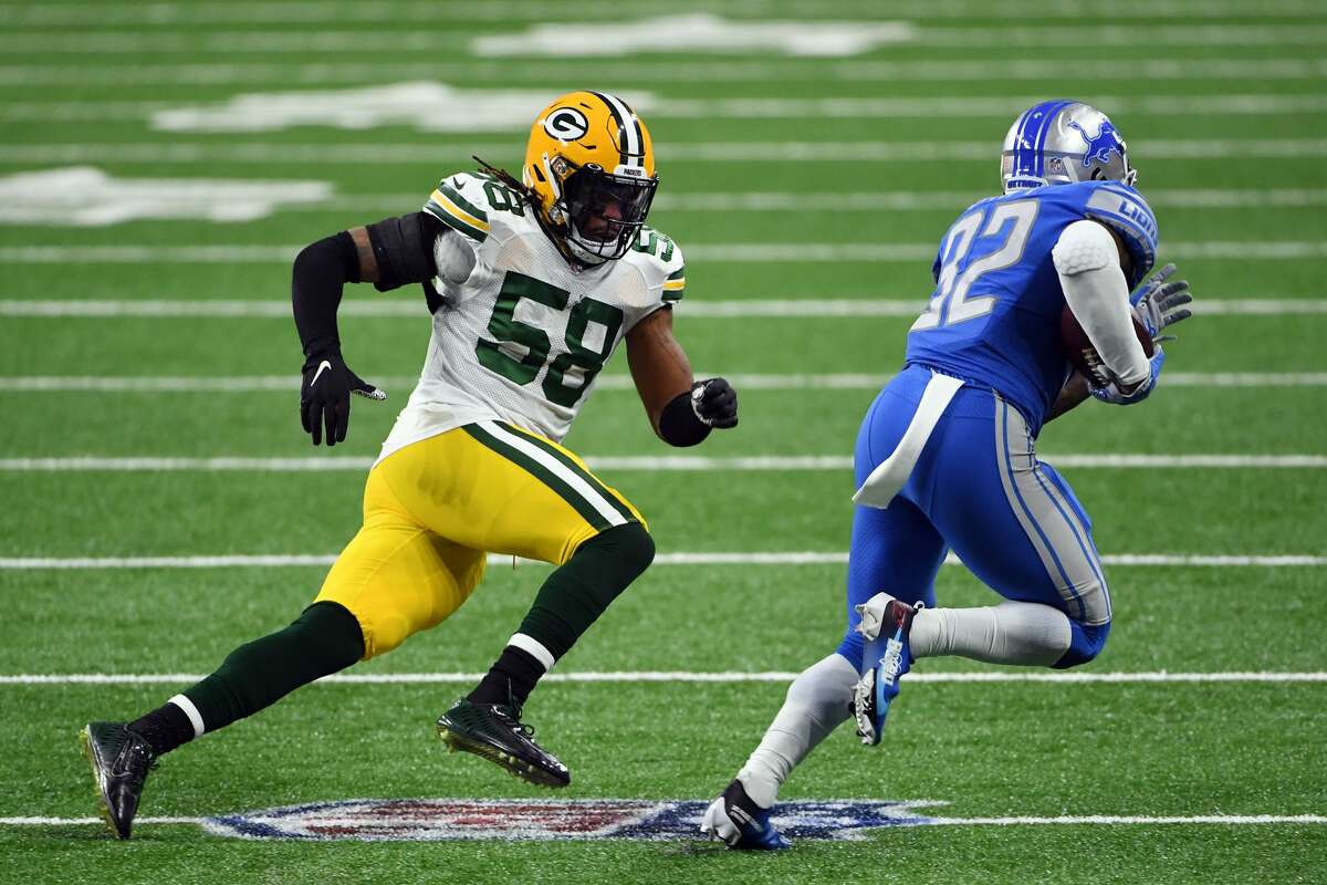 DETROIT, MICHIGAN - DECEMBER 13: Christian Kirksey #58 of the Green Bay Packers chases D'Andre Swift #32 of the Detroit Lions during the second half at Ford Field on December 13, 2020 in Detroit, Michigan. (Photo by Nic Antaya/Getty Images)