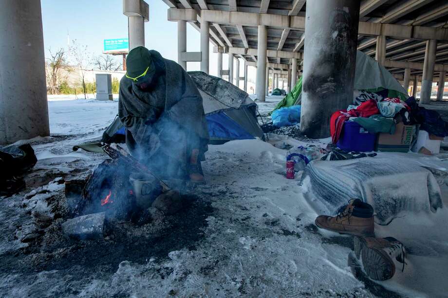 A man who goes by the name ‘Snipe’ tries to keep warm a the fire. Despite temperatures hitting the single digits, many unsheltered people like Snipe decided to stay put instead of seeking emergency shelter indoors. Photo: Jessica Phelps /San Antonio Express-News / **MANDATORY CREDIT FOR PHOTOG AND SAN ANTONIO EXPRESS-NEWS/NO SALES/MAGS OUT/TV  © 2021 San Antonio Express-News