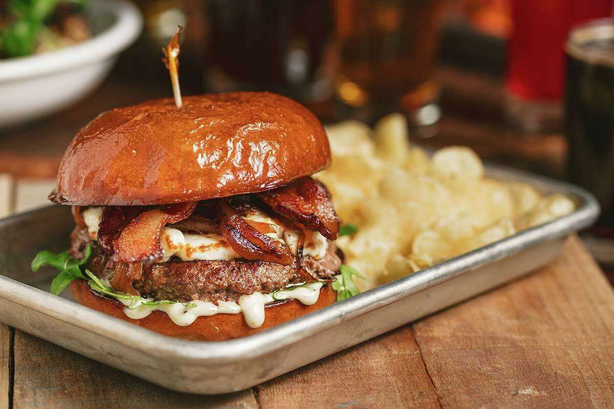 The Ol' Blue Burger: Broad Brook beef, blue cheese, caramelized onions, applewood smoked bacon, arugula, roasted garlic aioli and house pickles served on a brioche bun from Hartford Baking Co., with a side of kettle chips.