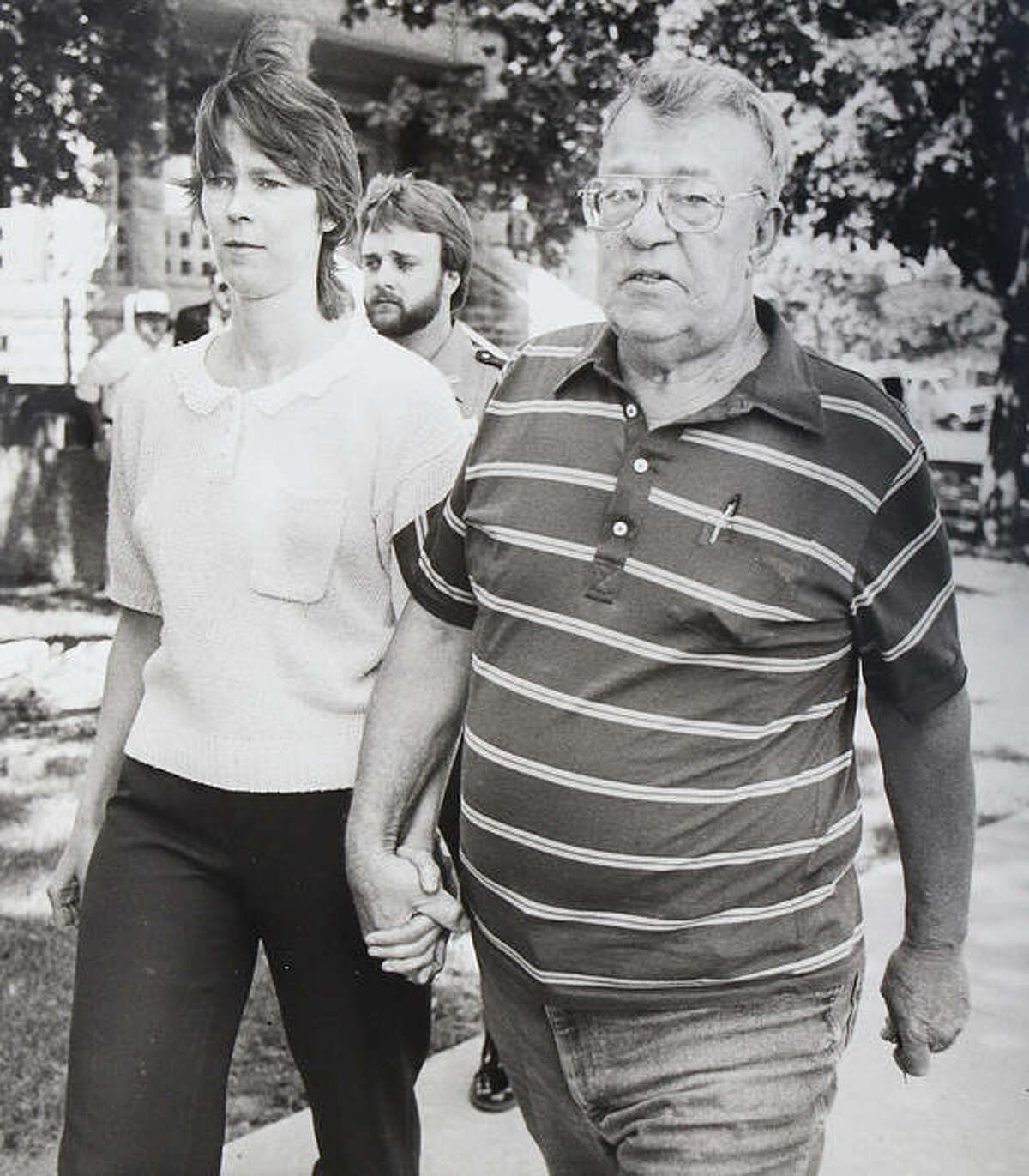 Paula Sims holds the hand of her father, Orville Blew, as they leave the Jersey County Courthouse after posting bond in May of 1989 on four felony charges related to the death of her first daughter, Loralei Marie Sims, who died in 1986.