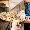 Rich Rosen takes out one of the Pi Bar's signature mushroom sauce pizza out of the oven at his restaurant in San Francisco, Calif. on March 12, 2021.