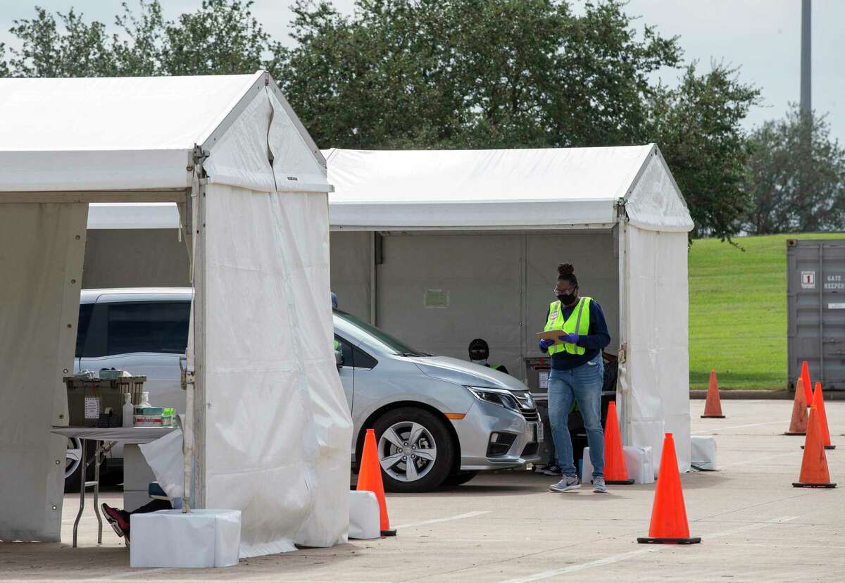 A Harris County staff member assists a voter at the drive-thru polling place Oct. 17 at NRG Arena in Houston. Senate Bill 7 would eliminate this service.