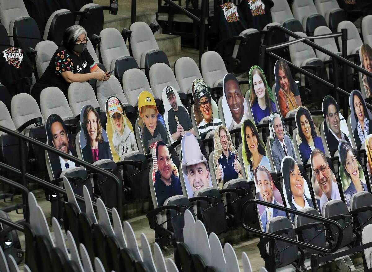 A spectator sits behind a rows of cutouts before the Spurs game against the Orlando Magic at the AT&T Center on Friday, Mar. 12, 2021. This was the first game since the start of the Covid-19 pandemic that fans were allowed to watch a game in person.