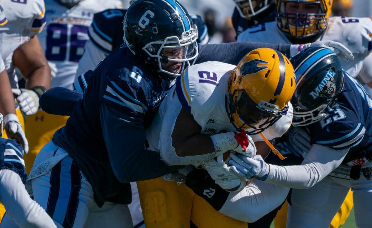 UAlbany running back Karl Mofor power through Maine defenders Deshawn Stevens (6) and Adrian Otero in a Colonial Athletic Association football game Satureay, May 13, 2021, at Orono, Maine. Mofor rushed for 155 yards on 30 carries, but the UAlbany lost the game, 38-34. (Ronald Gillis/Maine athletics)
