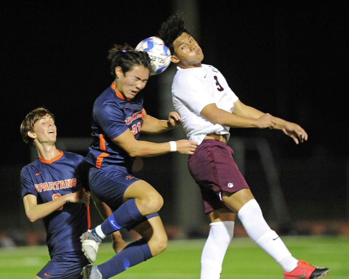Julian Arai (21) of Seven Lakes and Danny Vargas (9) of Cinco Ranch compete for a head shot during the second half of a 6A-III District 19 soccer match between the Seven Lakes Spartans and the Cinco Ranch Cougars on Friday, March 12, 2021 at Seven Lakes HS, Katy, TX.