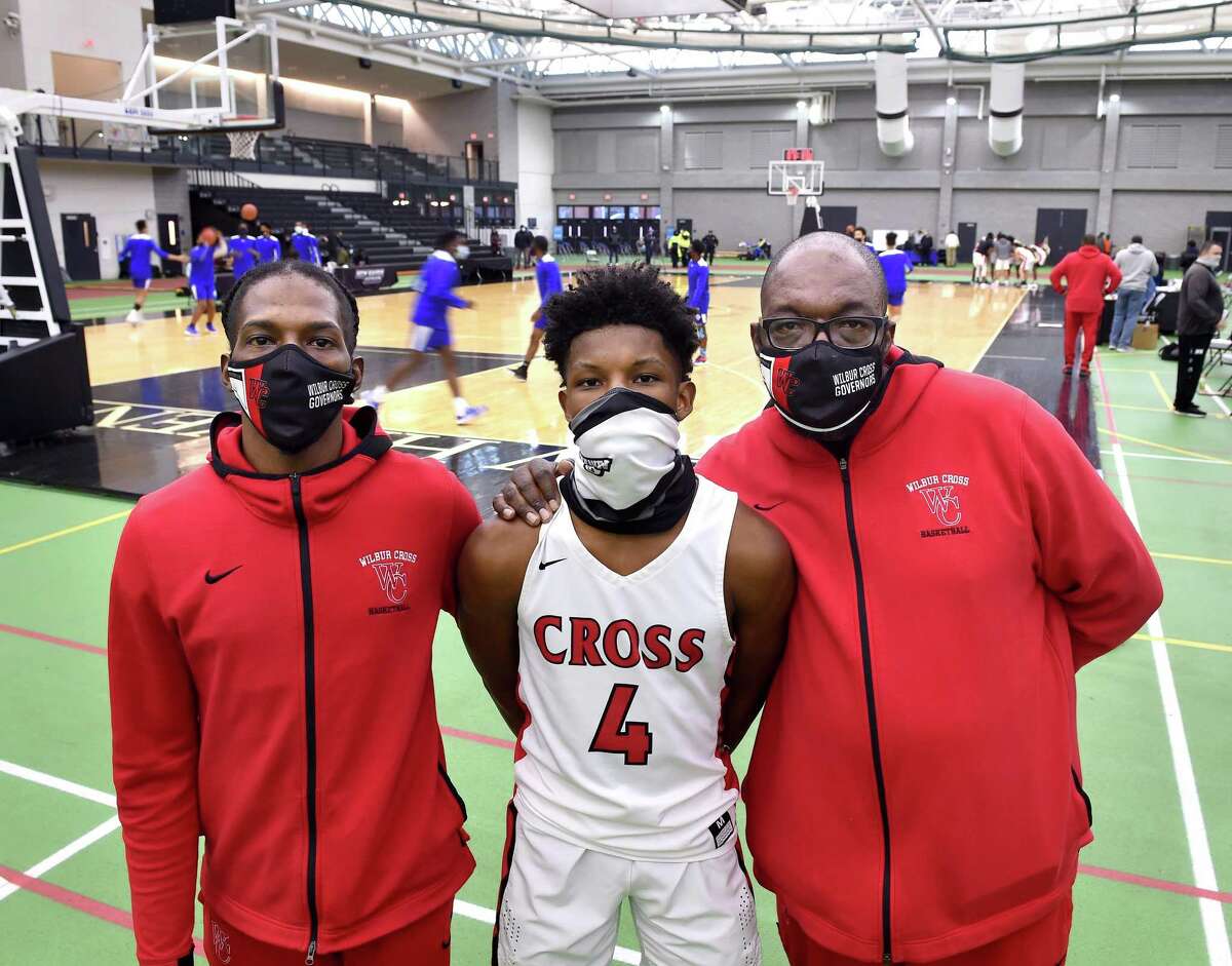 Wilbur Cross boys basketball assistant coach Gerald McClease, Sr. (right), is photographed with his son, Gerald McClease, Jr. (left) and grandson, Christian McClease (center), before a game at the Floyd Little Athletic Center in New Haven on March 6, 2021.