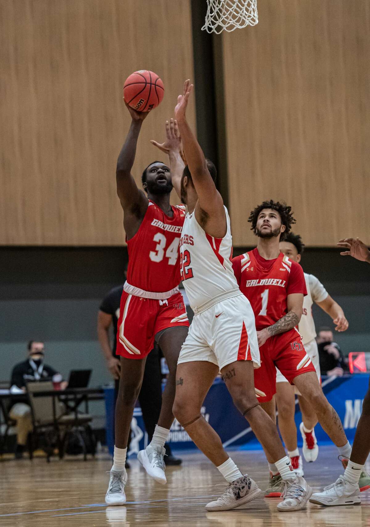 Caldwell's Manley Dorme attempts a shot over Dominican's Donnell Hill in a NCAA Division II basketball regional game Saturday, March 13, 2021, at the Albany Capital Center. Caldwell's Anthony Cooper is in the background. (Robert Simmons/ACC)