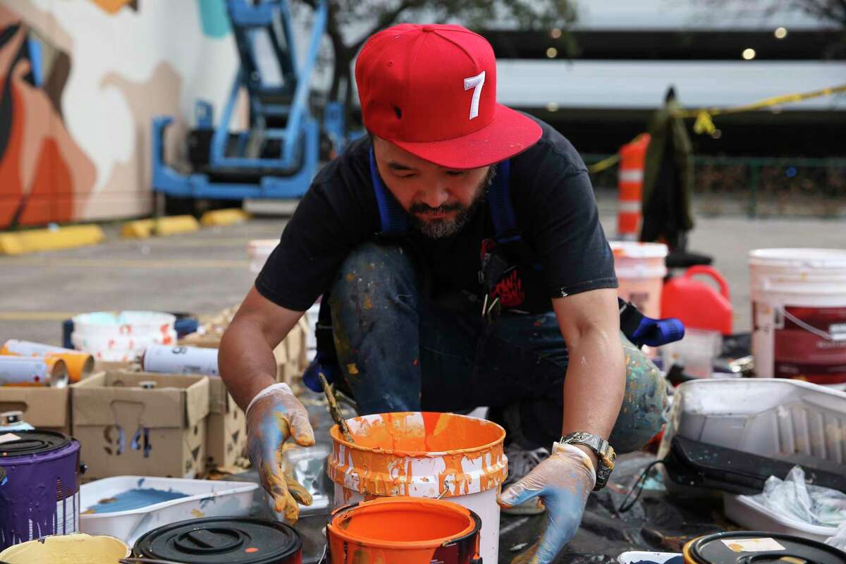 Artist Satoshi "Dragon76" Fujita mixes paints for the "Zero Hunger" mural, one of the largest in the city, that he is creating on Wednesday, March 10, 2021, in Houston. The mural was created to "raise awareness and mobilize action to combat global food insecurity and, in the US, food injustice that disproportionately impacts African-Americans communities."