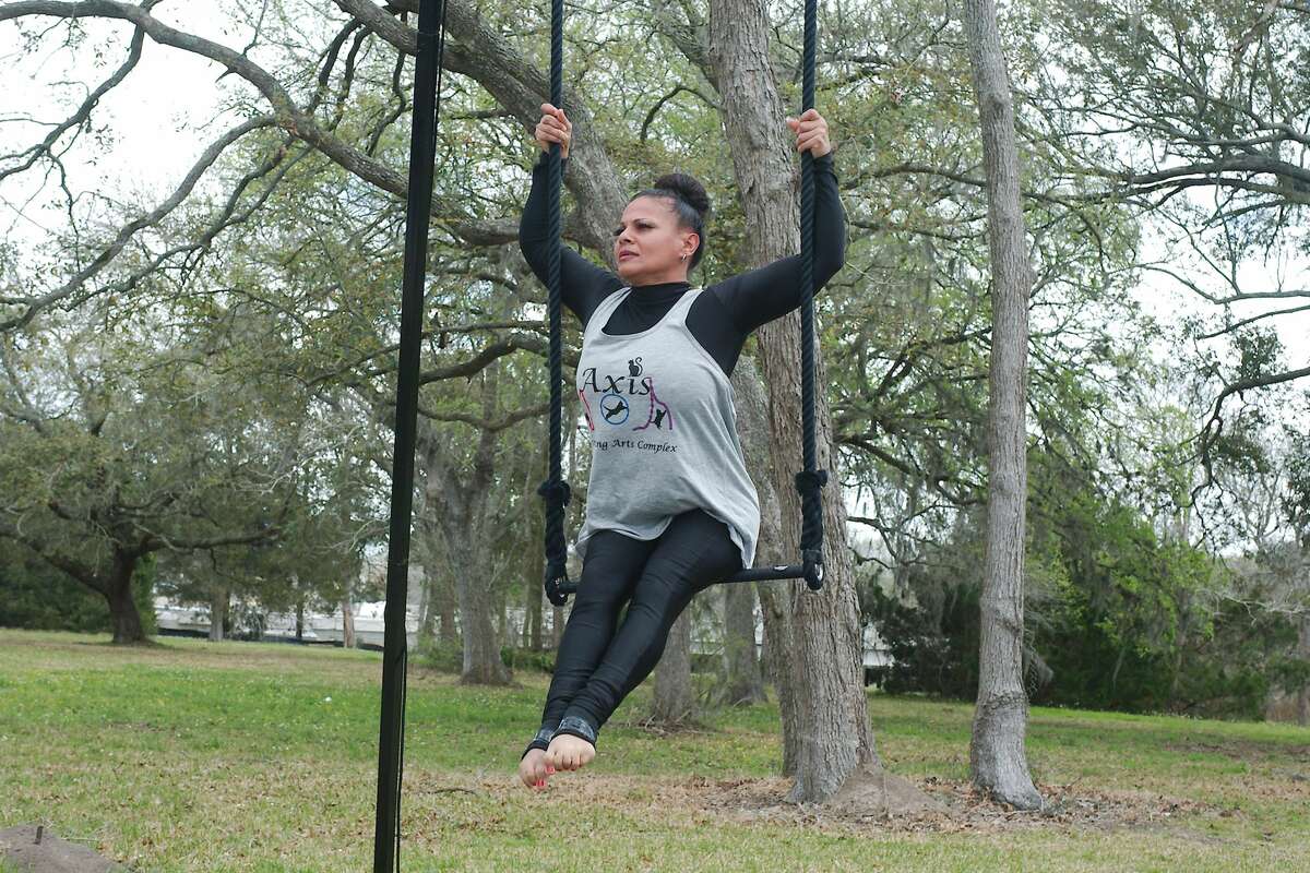 Cynthia Morales with Axis Performing Arts Complex performs on the trapeze at the Dickinson Little Italy Festival Saturday at Water Grove Event Venue in Dickinson.