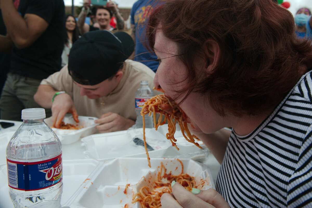 CJ Crider and Brittany Calhoun compete for second place in the spaghetti eating contest during the Dickinson Little Italy Festival Saturday at Water Grove Event Venue in Dickinson.