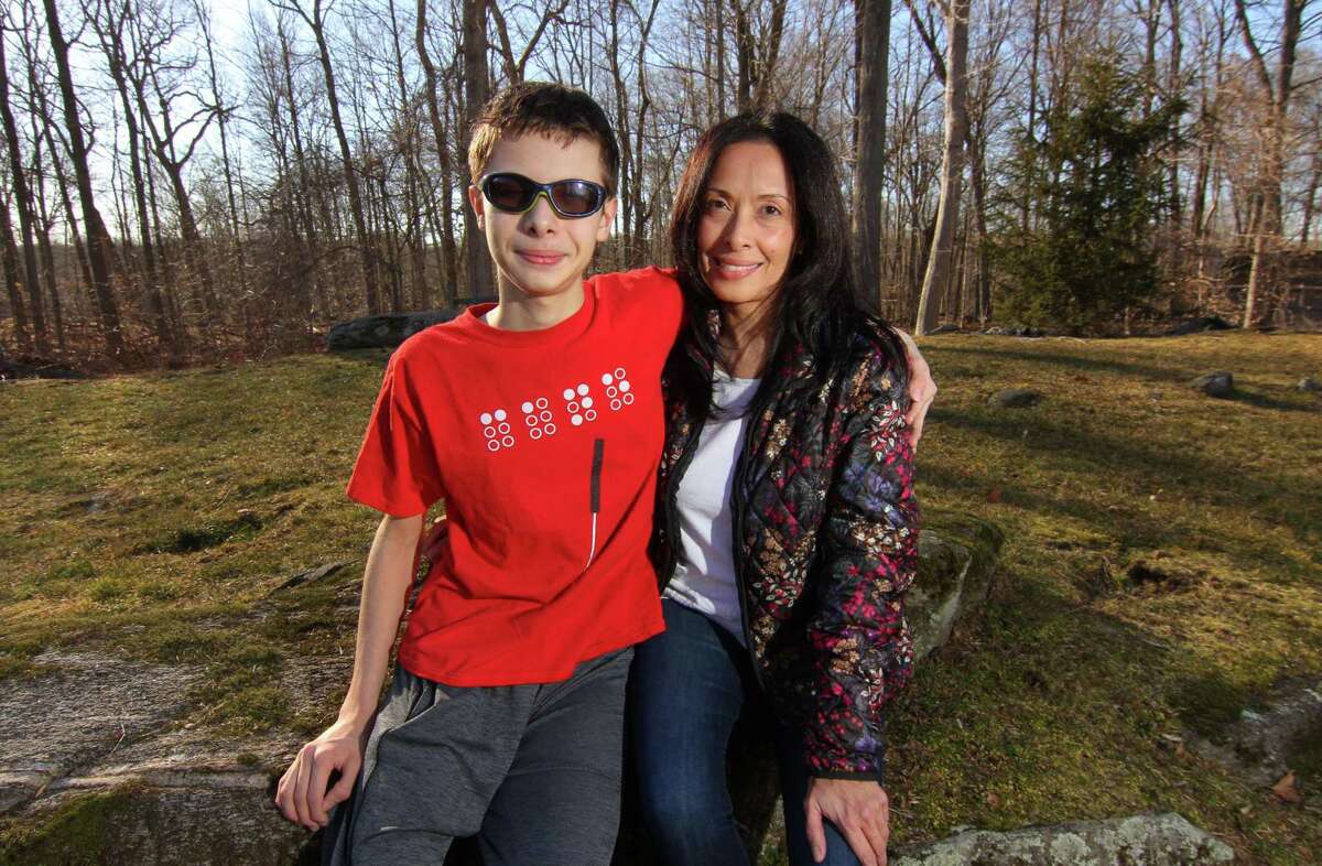 Mabel Balestra and her son Pierluca, 14, who is legally blind, pose together at their home in Greenwich, Conn., on Friday Mar. 12, 2021. Balestra recently won a state complaint against the district alleging that Greenwich Public Schools failed to provide adequate special education services. Balestra is using the success of that case to try to bring more sweeping change to the district's special education services and provide better access for all students.